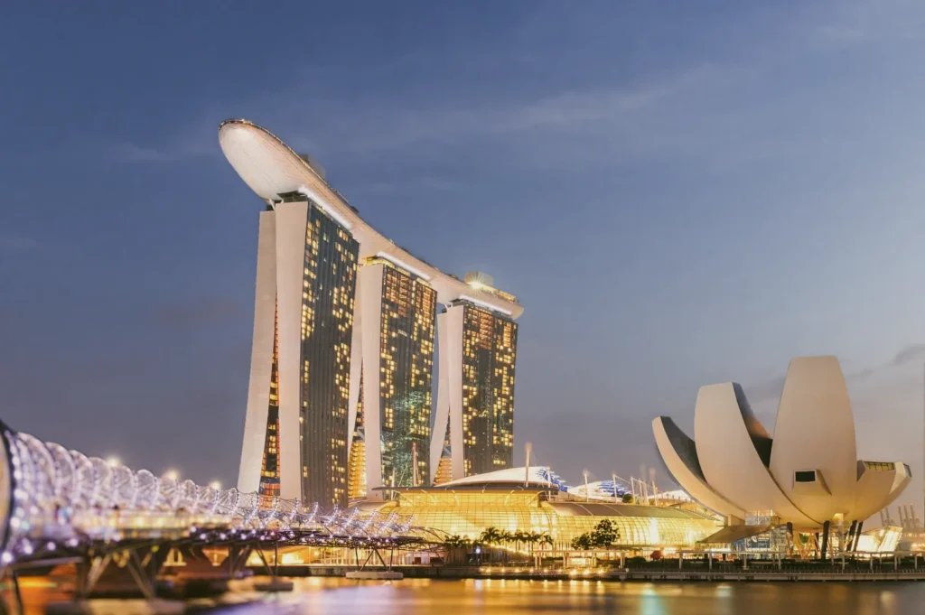 Low‑angle wide shot of Marina Bay Sands skyline at dusk, featuring luxury hotel towers and waterfront architecture in Singapore, iconic dining and travel landmark.