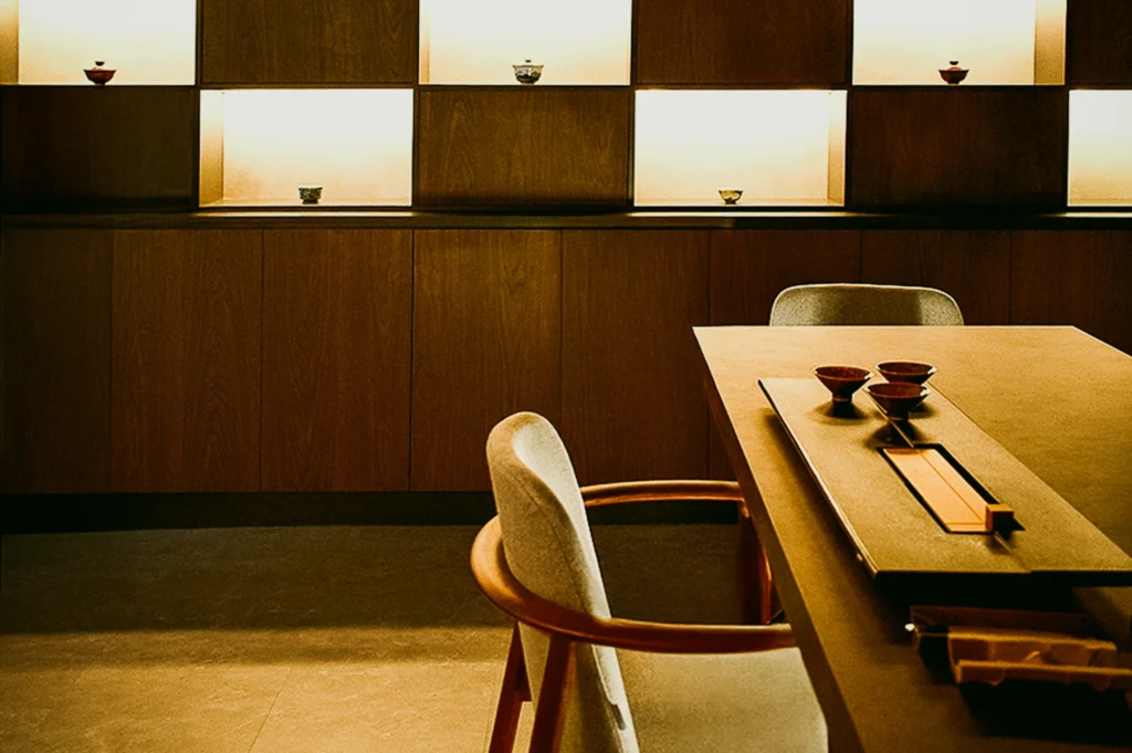 Minimalist private tea room at Tea Room by Ki-setsu in Singapore with wooden interiors, curated teaware, and soft ambient lighting – wide eye-level interior shot emphasizing luxury tea experience and intimate setting