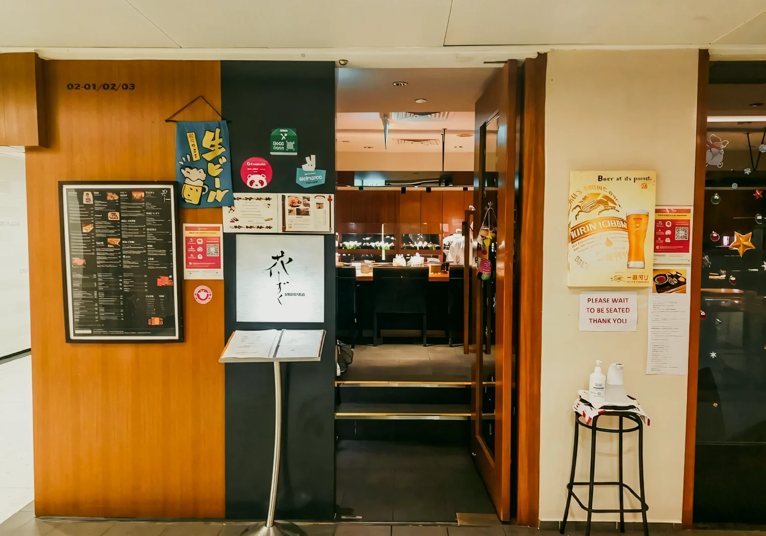1 Hanashizuku Japanese Cuisine Hanashizuku Japanese Cuisine entrance at Cuppage Plaza with menu board, cozy izakaya-style interior and signage for a hidden Japanese restaurant in Singapore, shot angle: eye-level wide front view.