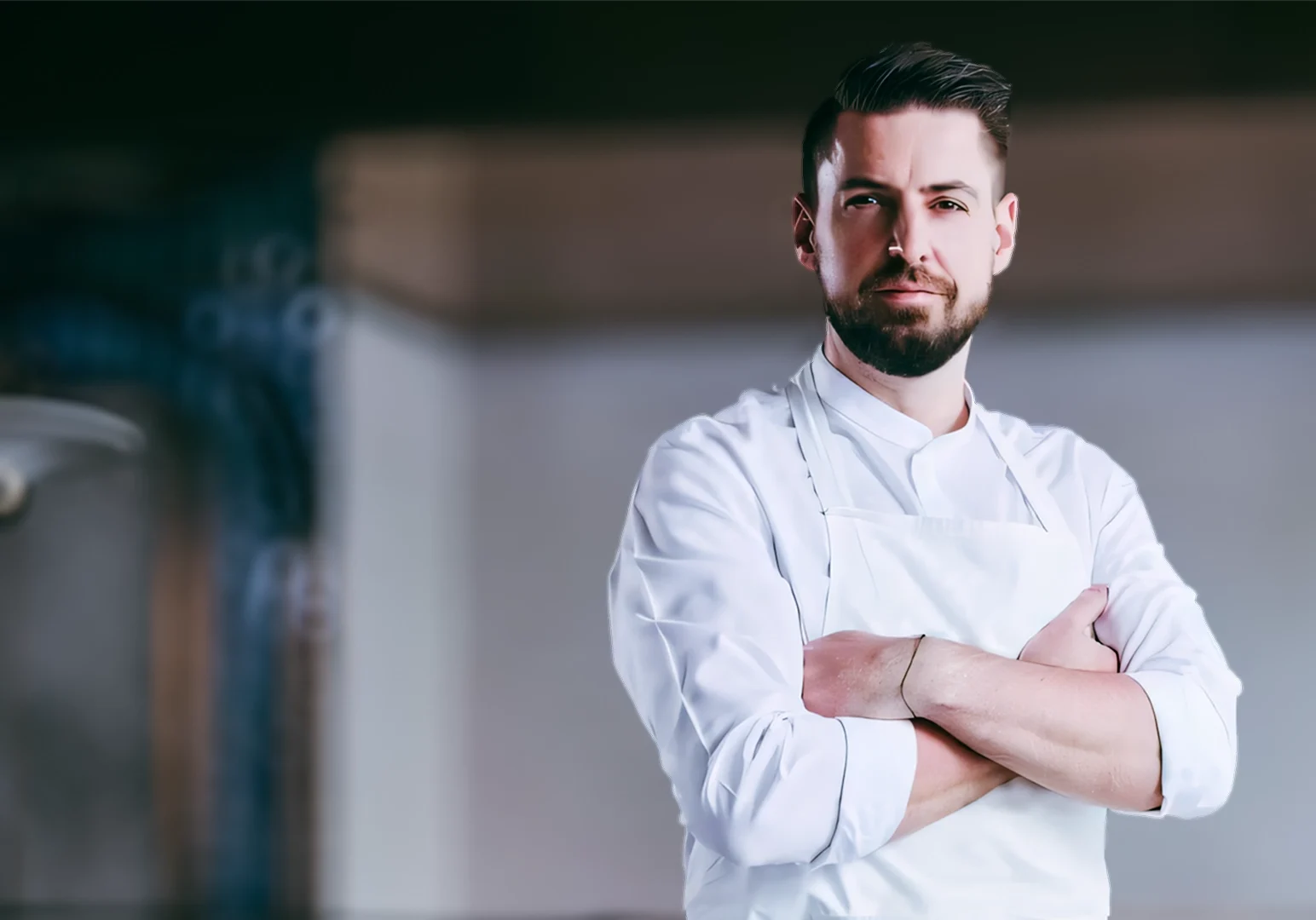 1 Kirk Westaway Chef Kirk Westaway wearing a white apron standing with folded arms in an elegant dining room setting.