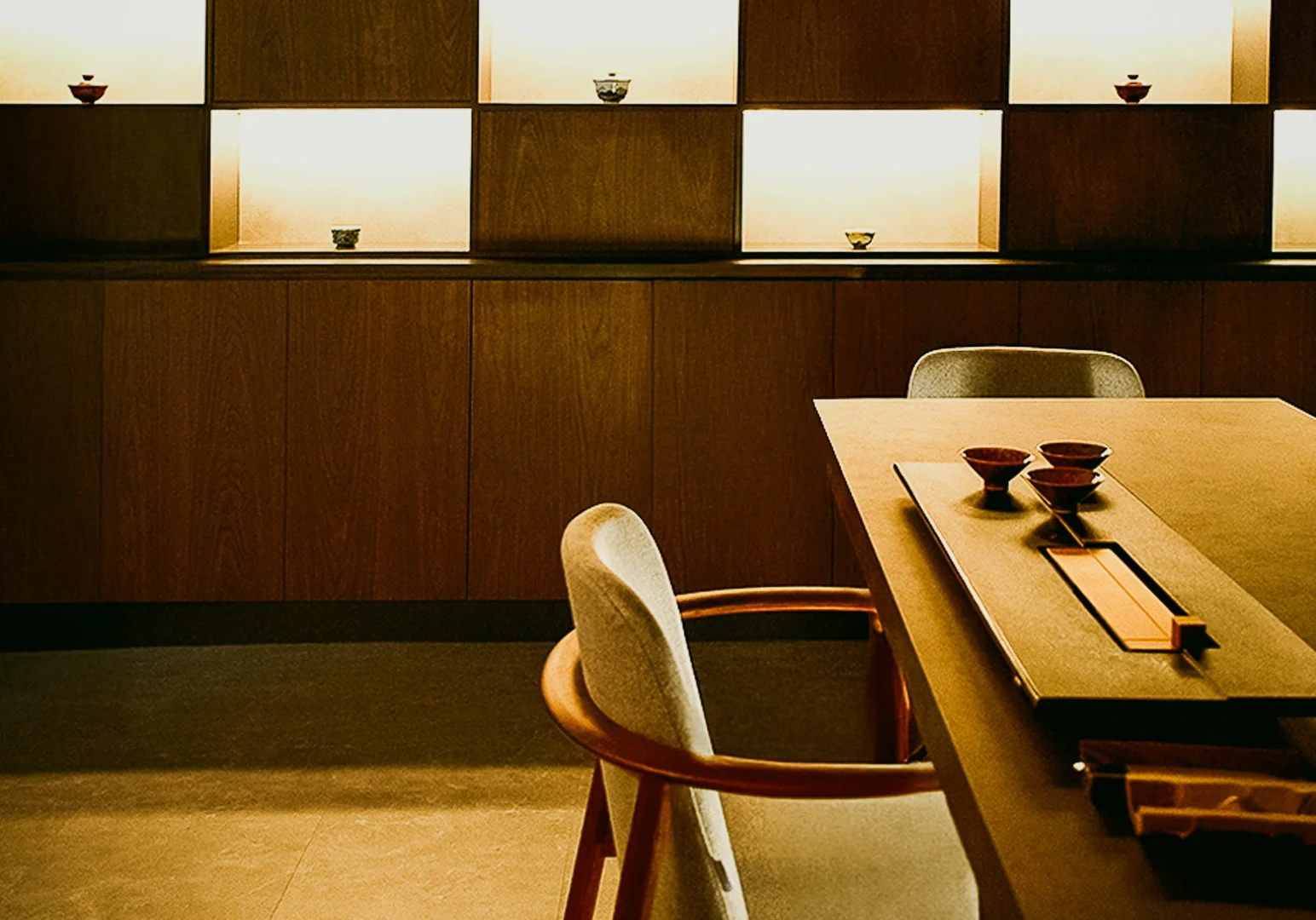 Minimalist private tea room at Tea Room by Ki-setsu in Singapore with wooden interiors, curated teaware, and soft ambient lighting – wide eye-level interior shot emphasizing luxury tea experience and intimate setting