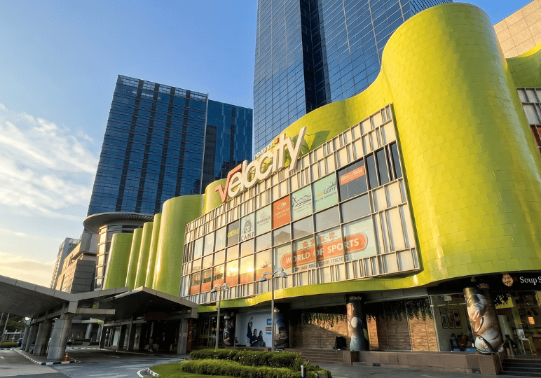 1-curry-times-velocity The exterior facade of the Velocity shopping mall in Singapore featuring a bright green curved wall.