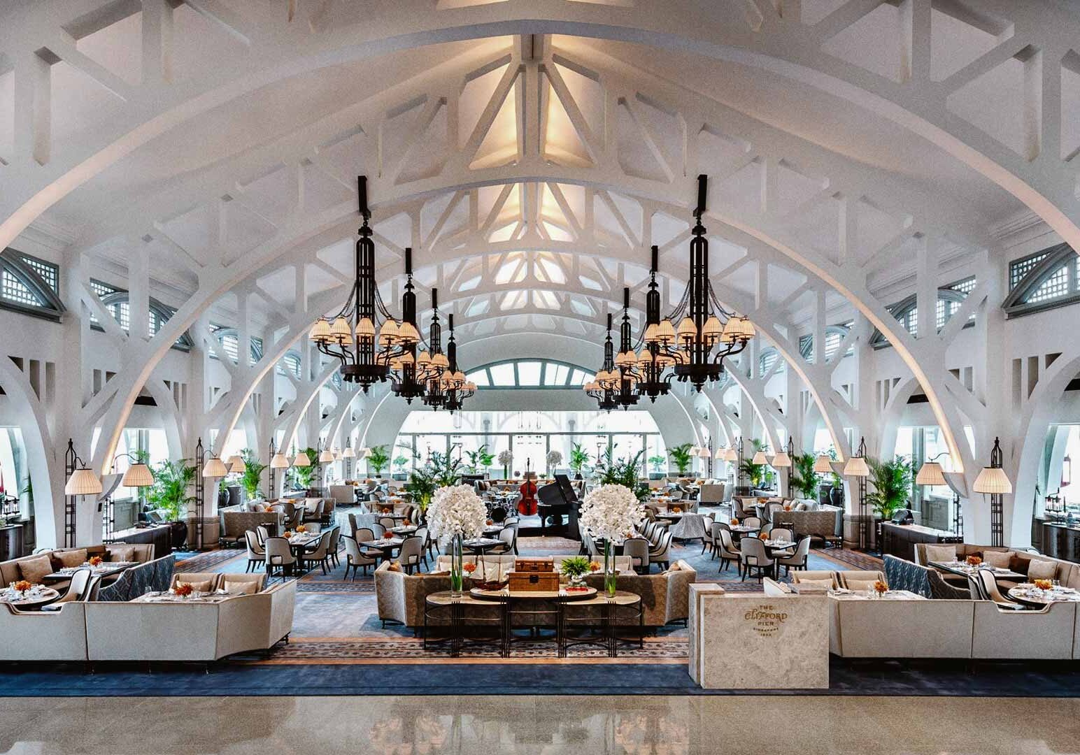 Grand colonial-style dining hall with high arches and chandeliers.