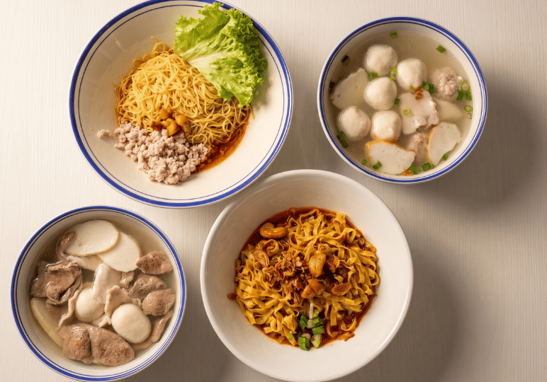 15-orchard-plaza-stalls A classic local spread of Bak Chor Mee consisting of four bowls: two featuring dry noodles tossed in a rich, savory sauce and minced pork, and two bowls of clear soup filled with meatballs, fishcakes, and offal.
