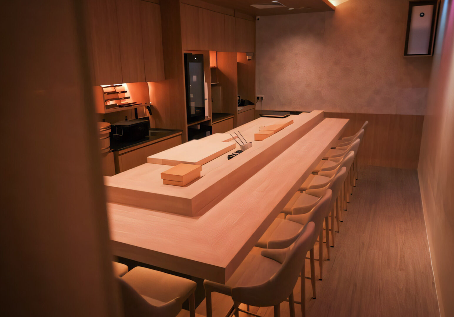 Minimalist Japanese sushi bar with long wooden counter, ten upholstered chairs, ambient lighting, and chopsticks holder.