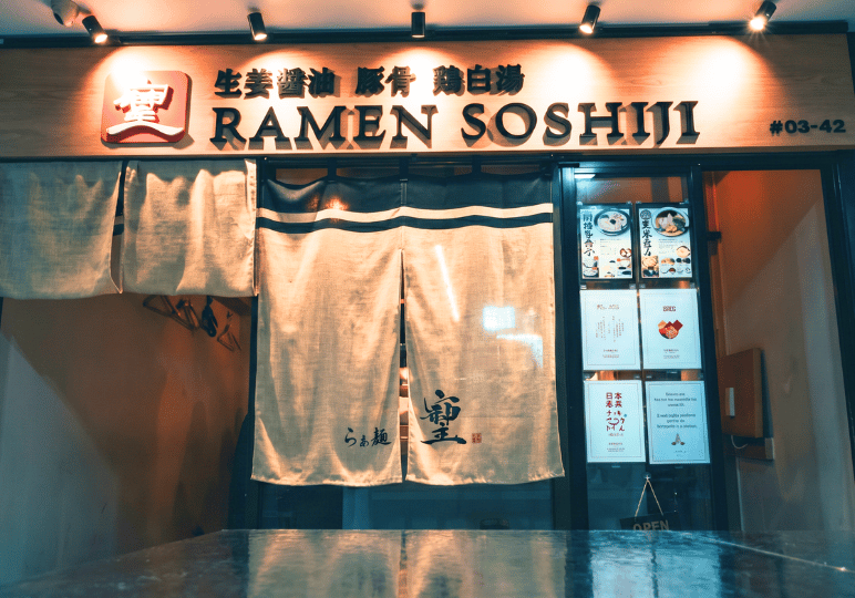 2-orchard-plaza-stalls The inviting storefront of Ramen Soshiji at Orchard Plaza, featuring a wooden sign and a traditional split linen noren curtain over the entrance.