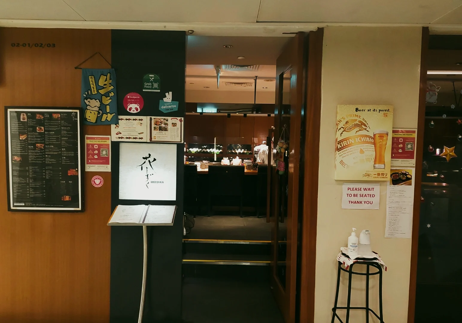3 Cuppage Plaza Food Eye-level corridor shot of a Japanese restaurant entrance in Cuppage Plaza with menu display and signage, highlighting cozy izakaya dining atmosphere in Singapore