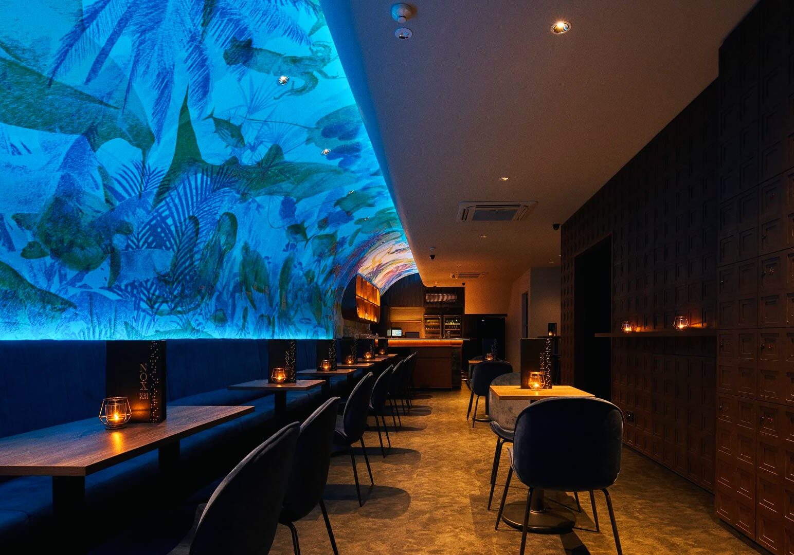 Nighttime view of Clarke Quay with vibrant lights and river cruise boats.