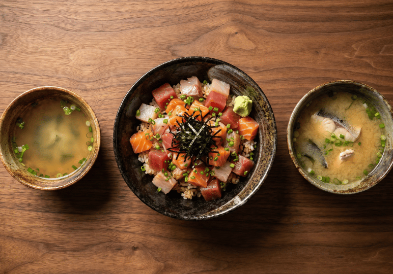 5-orchard-plaza-stalls A vibrant Bara Chirashi rice bowl topped with colorful diced sashimi, served on a wooden table alongside a bowl of clear soup and a bowl of miso fish soup.