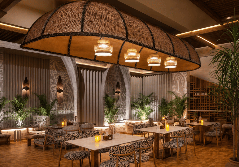 6-restaurant-interior A moody, tropical-themed restaurant dining room with boldly patterned armchairs, lush potted palms, and a striking, large woven boat-shaped canopy suspended over the central tables.