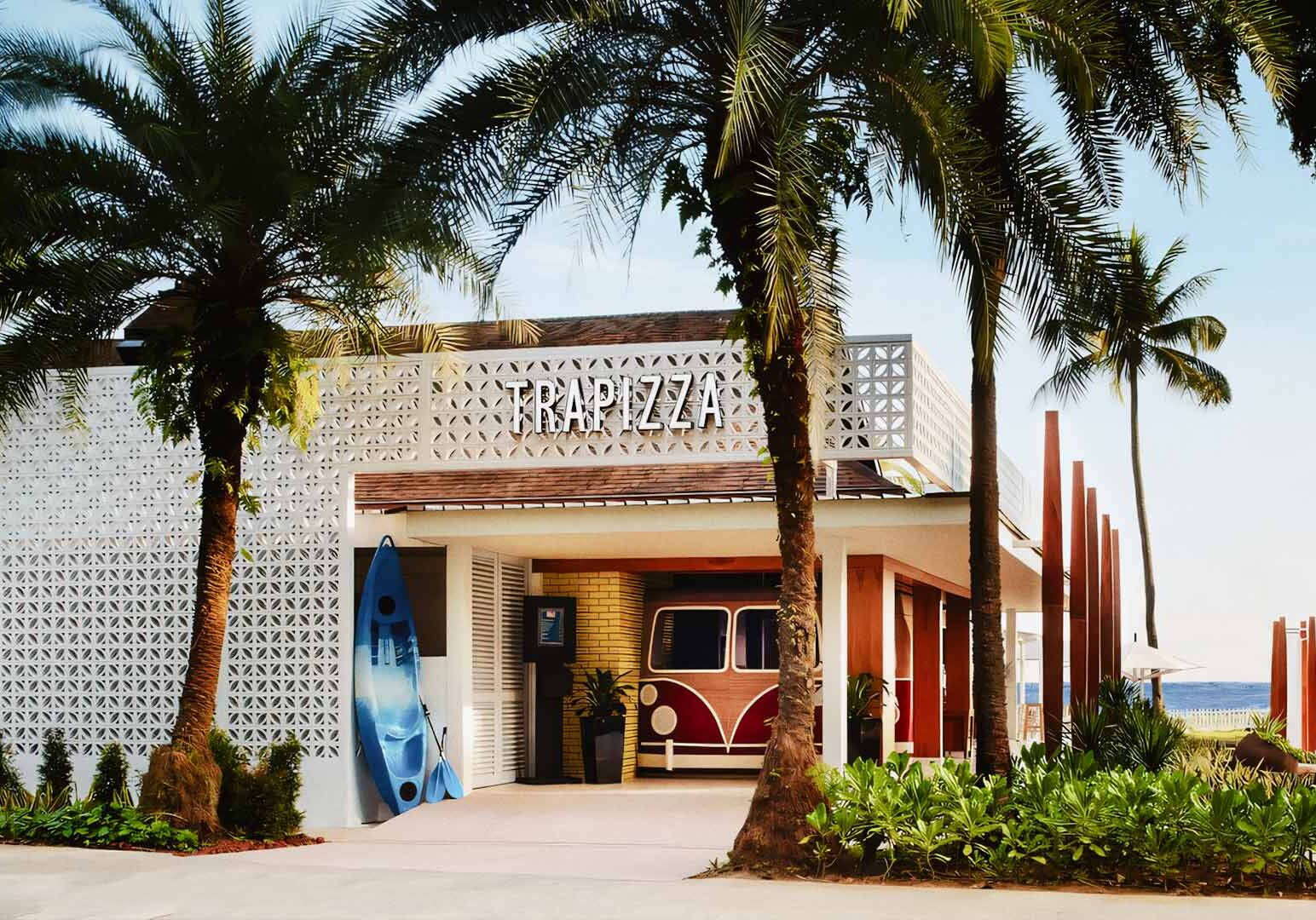 Trapizza beachfront restaurant with tropical palm trees and coastal design.