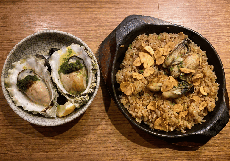 9-orchard-plaza-stalls Two fresh oysters on the half-shell with an herb topping served next to a cast-iron skillet filled with savory oyster fried rice and crispy garlic chips.