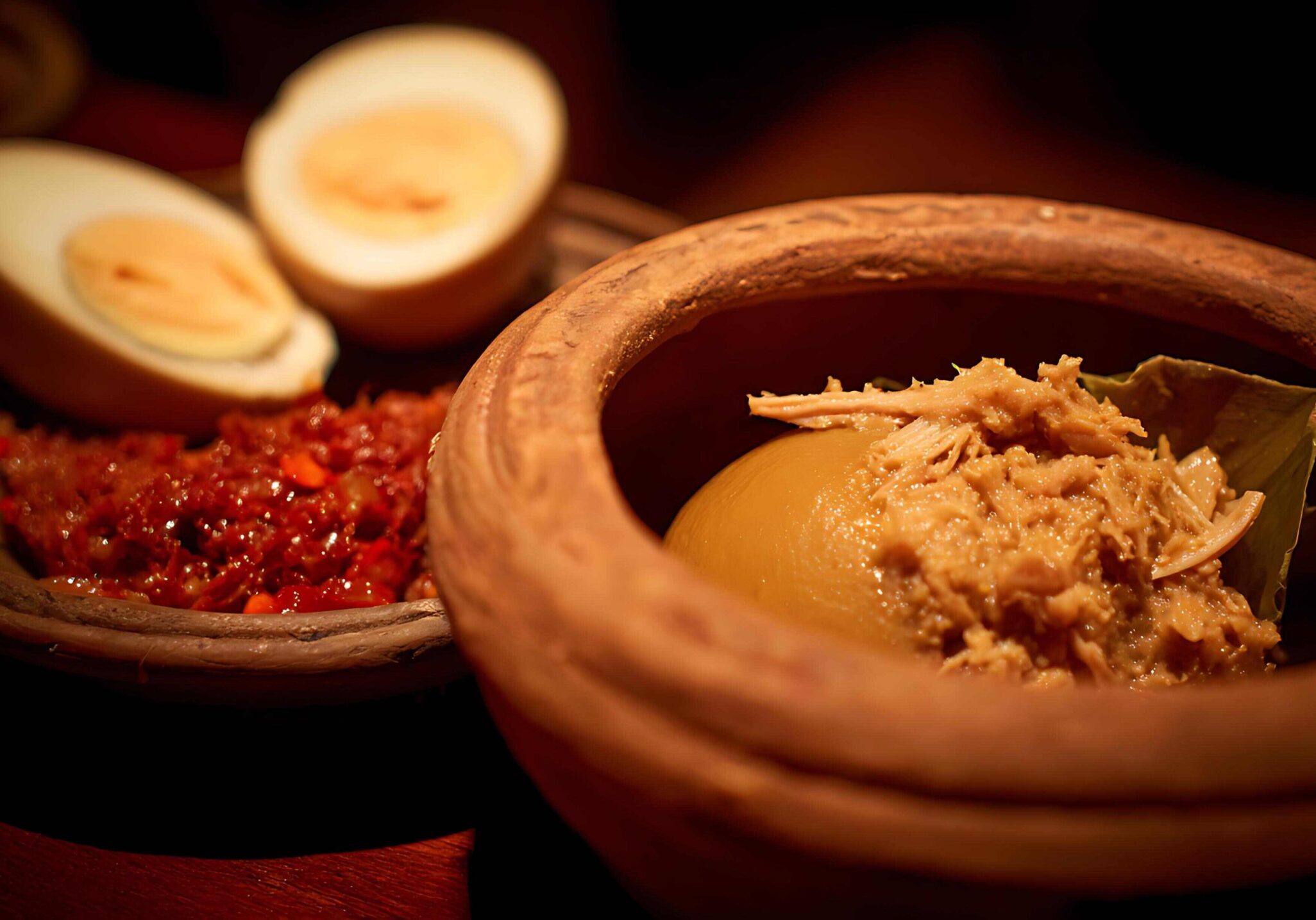 This close-up image features three classic Southeast Asian components, likely for a meal like Nasi Lemak or a side dish, presented in rustic clay bowls.