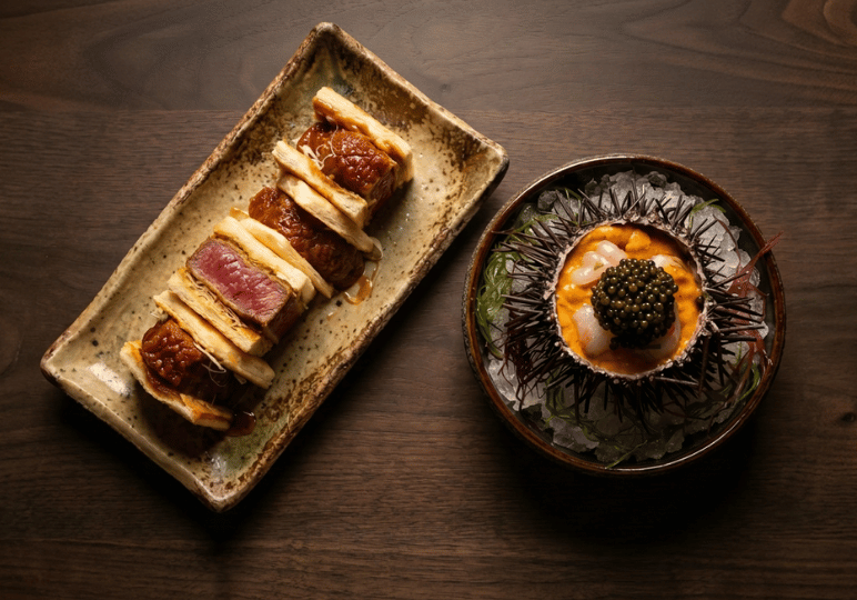 finedining-sg- (4) A top-down view of premium fine dining dishes, featuring a gourmet wagyu beef katsu sando alongside fresh sea urchin and shrimp topped with a generous mound of caviar.